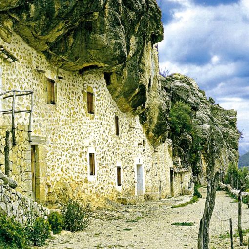 View of the old houses of Es Cosconar, built into caves in the valley below Lluc Monastery on Mallorca, Spain